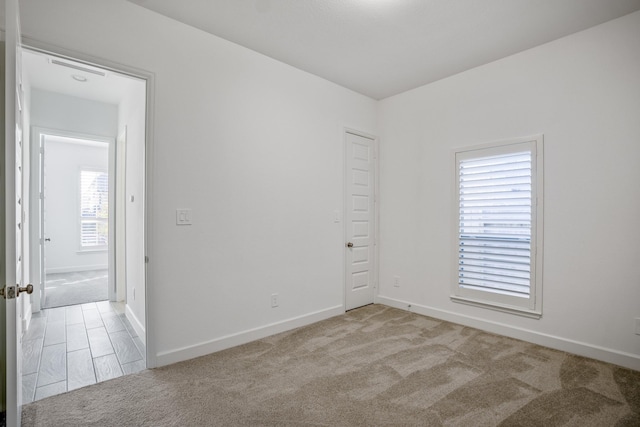spare room featuring light carpet