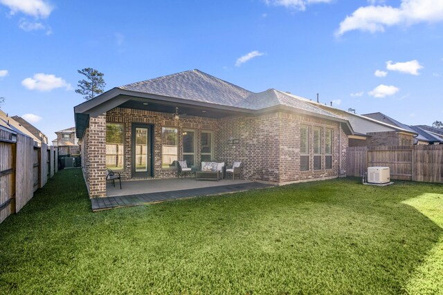 back of property with a lawn, ceiling fan, and a patio area