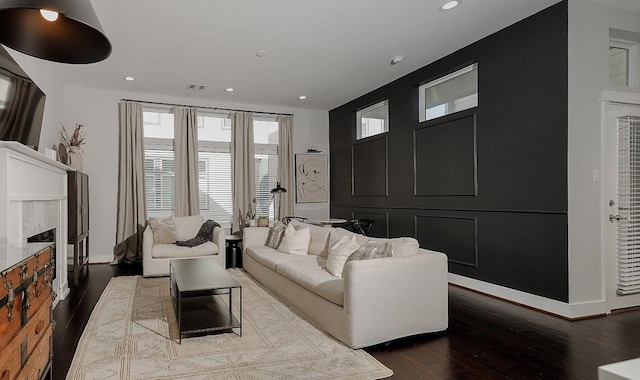 living room featuring wood-type flooring and a premium fireplace