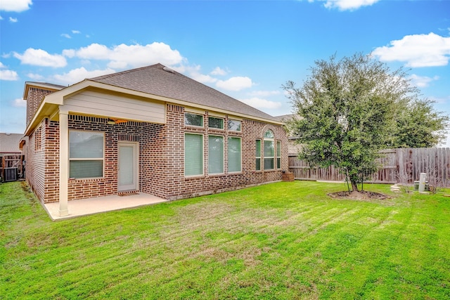 rear view of house featuring a lawn and a patio area