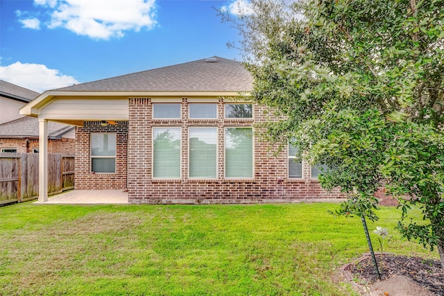 rear view of property featuring a lawn and a patio