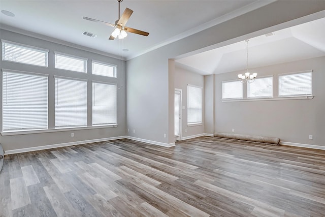 empty room with ceiling fan with notable chandelier, light wood-type flooring, and ornamental molding