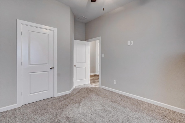 unfurnished bedroom featuring light colored carpet and ceiling fan