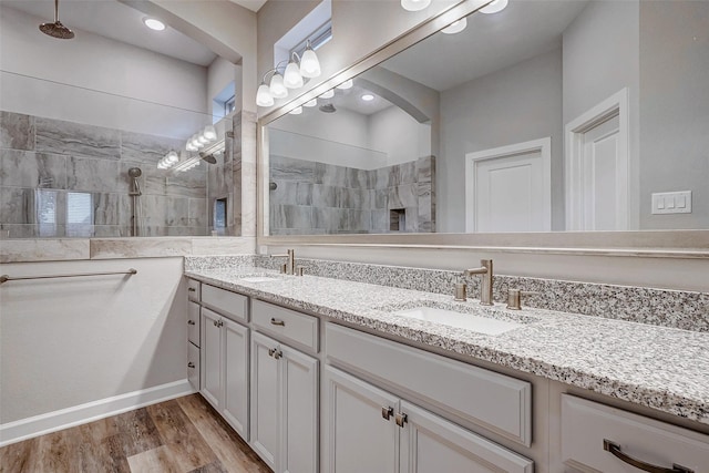 bathroom with wood-type flooring, vanity, and walk in shower