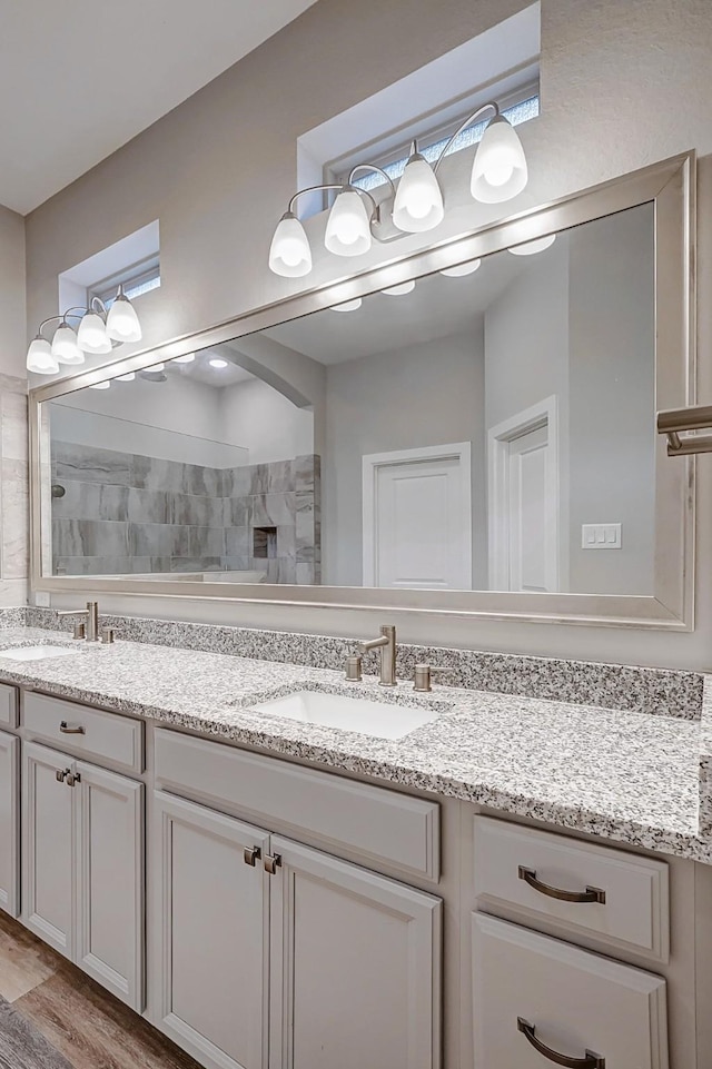 bathroom with hardwood / wood-style flooring, vanity, and walk in shower