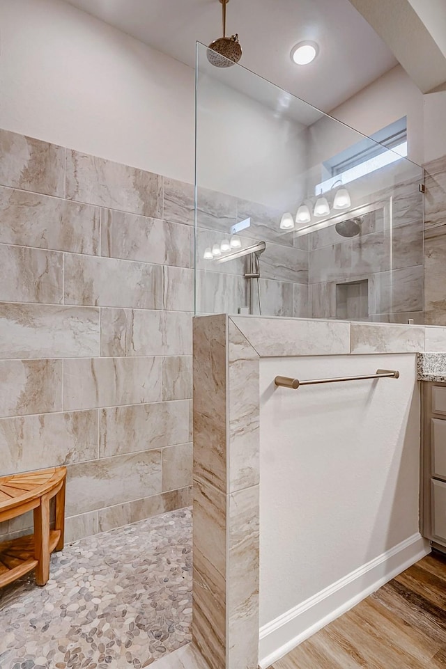 bathroom with vanity, wood-type flooring, and tiled shower