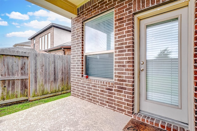 view of exterior entry with a patio area