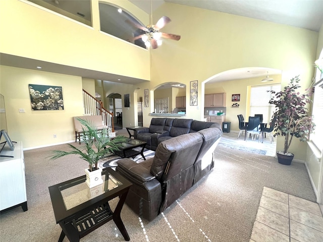 carpeted living room featuring high vaulted ceiling and ceiling fan