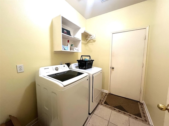 laundry area featuring light tile patterned flooring and washing machine and clothes dryer