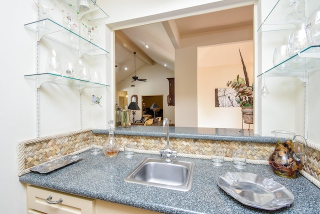 kitchen with decorative backsplash, vaulted ceiling with beams, ceiling fan, and sink