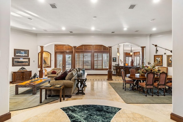 tiled living room featuring ornate columns and ornamental molding