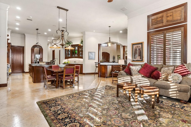 living room with an inviting chandelier and ornamental molding