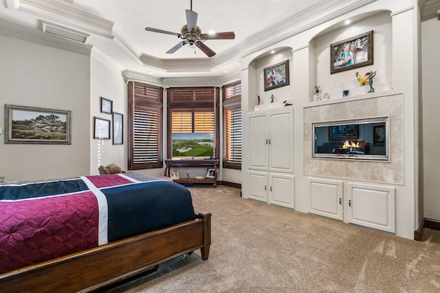 bedroom featuring light carpet, a tray ceiling, ceiling fan, and ornamental molding