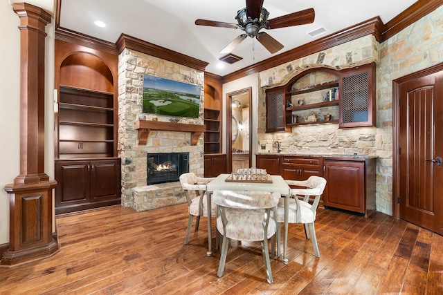 dining area with decorative columns, a fireplace, crown molding, and built in features