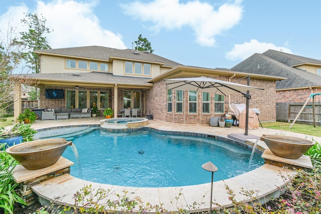 view of pool with an in ground hot tub, pool water feature, a patio, and an outdoor living space