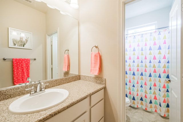 bathroom featuring a shower with curtain, vanity, and toilet