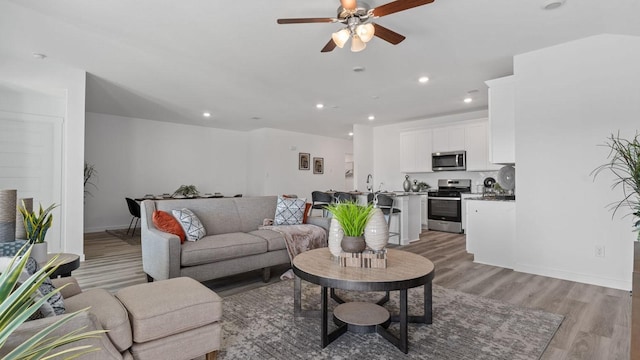 living room with light wood-type flooring and ceiling fan