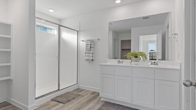 bathroom with hardwood / wood-style flooring, vanity, and a shower with door