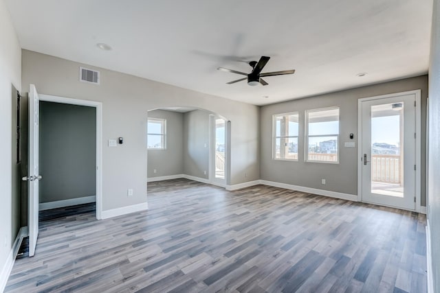 unfurnished room with ceiling fan, plenty of natural light, and light wood-type flooring