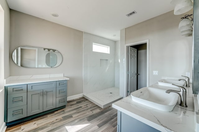 bathroom featuring a shower, wood-type flooring, and vanity