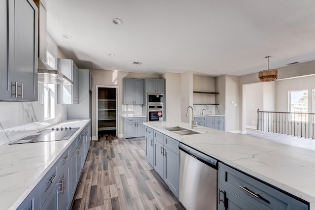 kitchen with a wealth of natural light, sink, stainless steel appliances, and hanging light fixtures