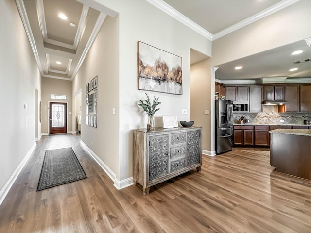 kitchen featuring stainless steel fridge with ice dispenser, light stone counters, wood-type flooring, decorative backsplash, and dark brown cabinets