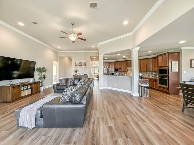 living room featuring ceiling fan, crown molding, and light hardwood / wood-style flooring