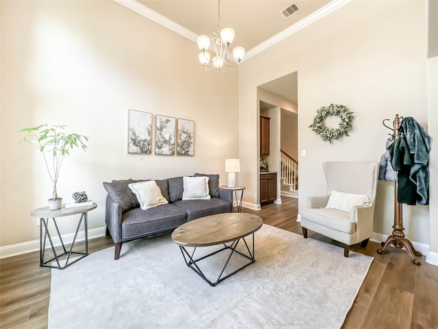 living room featuring hardwood / wood-style floors, ornamental molding, and a notable chandelier