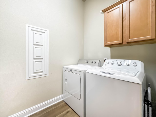 laundry room with cabinets, separate washer and dryer, and dark wood-type flooring