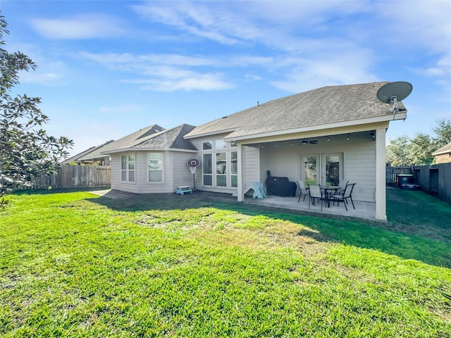 rear view of property with a lawn, a patio area, ceiling fan, and french doors