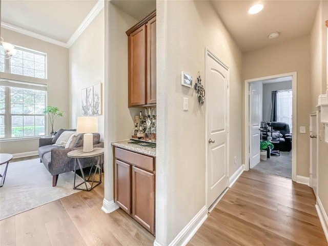 corridor with crown molding and light hardwood / wood-style flooring