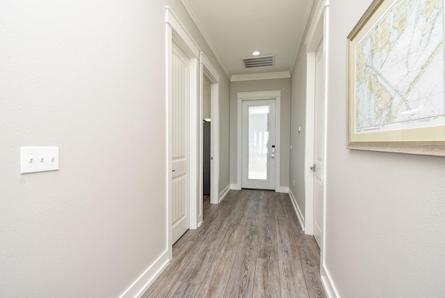 hall featuring light wood-type flooring and crown molding