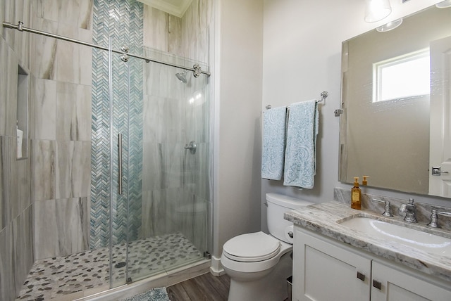 bathroom featuring toilet, a shower with door, vanity, and hardwood / wood-style flooring