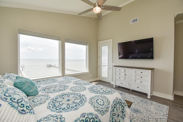 bedroom with ornamental molding, ceiling fan, dark wood-type flooring, and a high ceiling