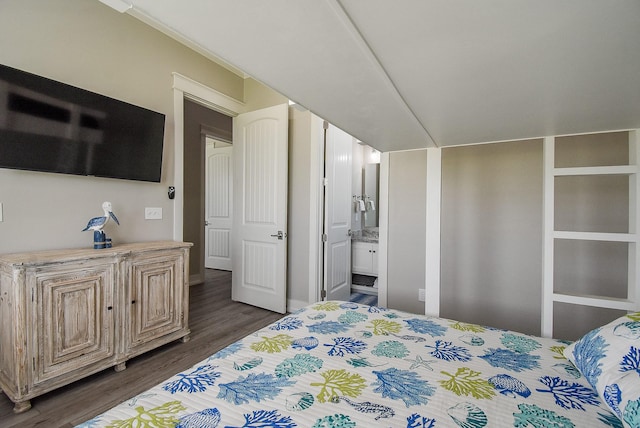 bedroom with ensuite bath and dark wood-type flooring