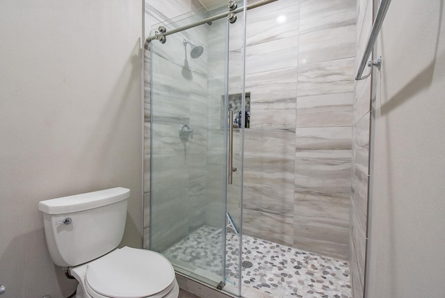 bathroom with toilet and a shower with shower door