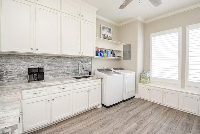 washroom with cabinets, sink, light hardwood / wood-style flooring, washer and dryer, and ornamental molding