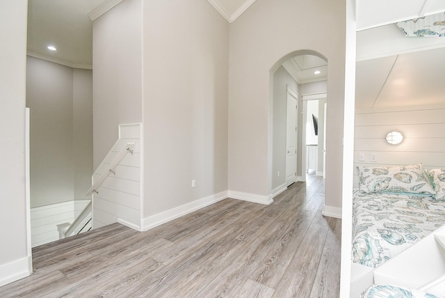 hall with light hardwood / wood-style floors and ornamental molding