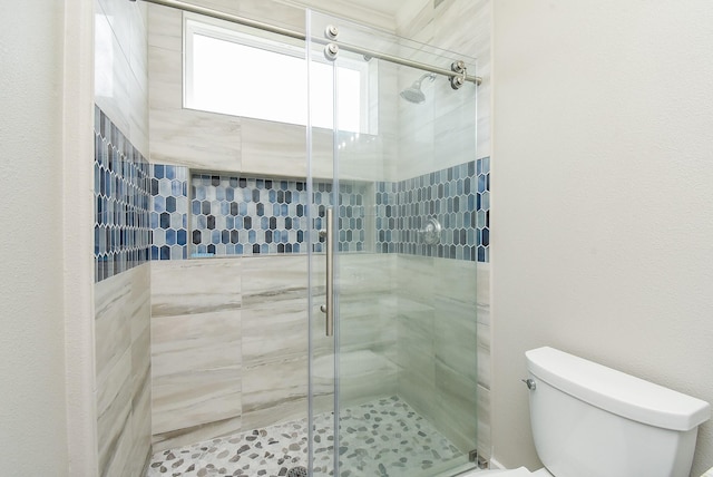 bathroom featuring an enclosed shower and toilet