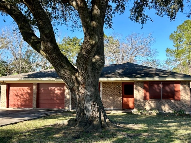 ranch-style house with a garage and a front lawn