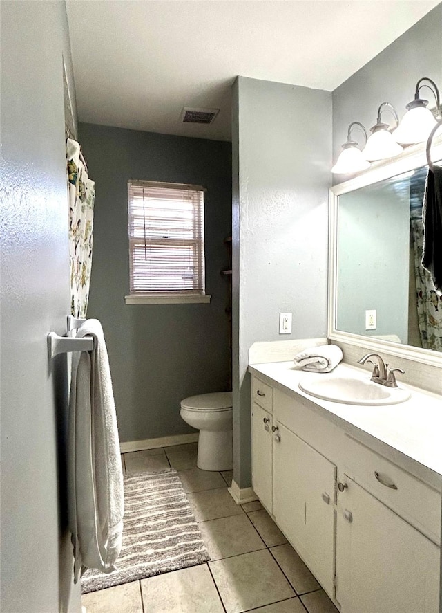 bathroom with tile patterned flooring, vanity, and toilet