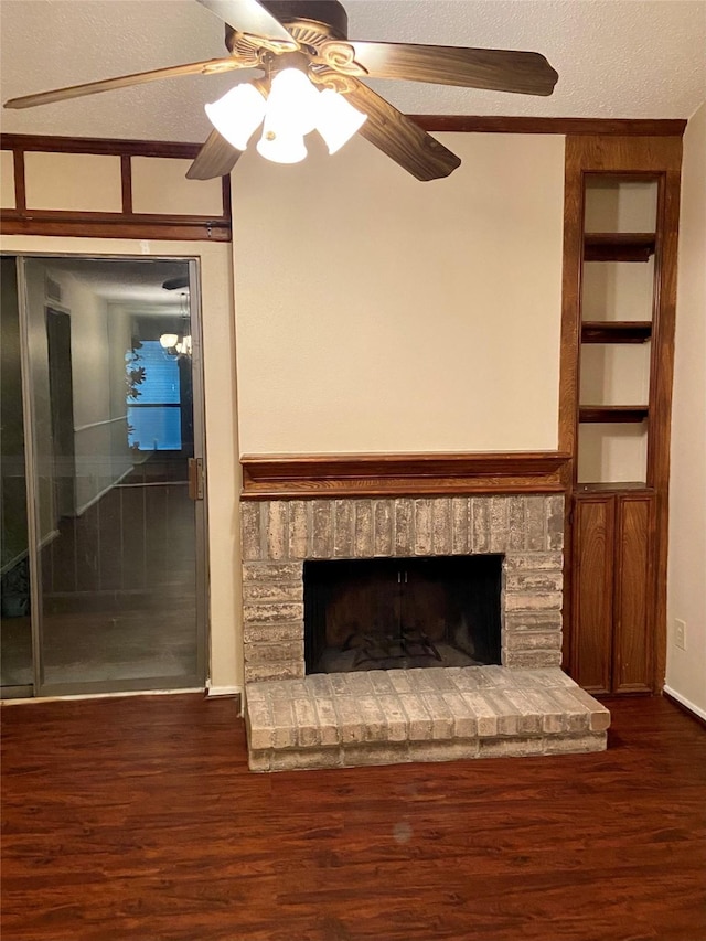 unfurnished living room featuring built in shelves, a brick fireplace, a textured ceiling, dark hardwood / wood-style flooring, and ceiling fan