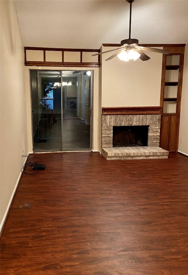 unfurnished living room with ceiling fan, a textured ceiling, dark hardwood / wood-style flooring, a brick fireplace, and vaulted ceiling