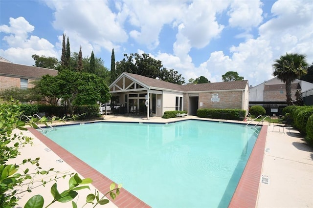 community pool featuring a patio area and fence