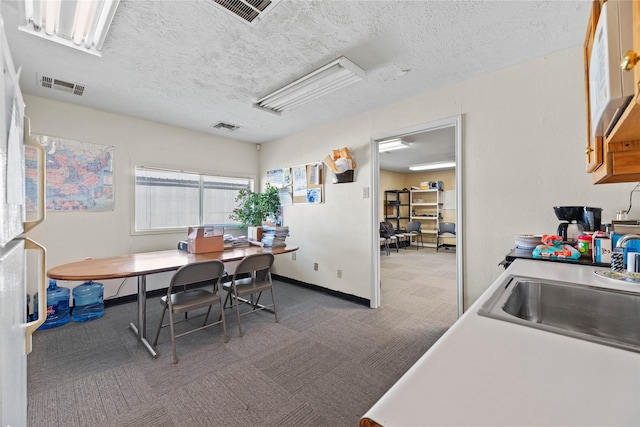 dining space featuring a textured ceiling and sink