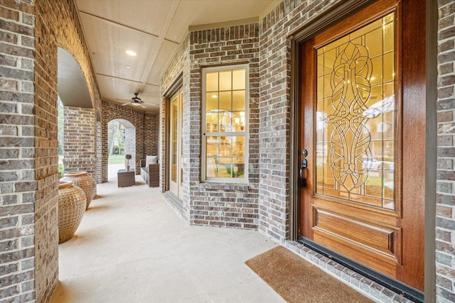 doorway to property with ceiling fan and a porch