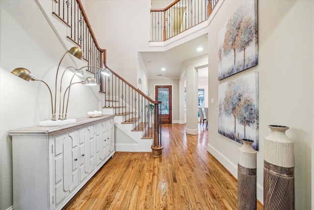 entrance foyer featuring a high ceiling, light hardwood / wood-style floors, and ornamental molding