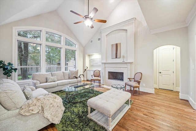 living room featuring ceiling fan, light hardwood / wood-style flooring, high vaulted ceiling, and ornamental molding