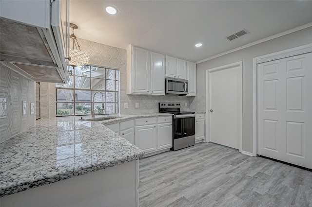 kitchen with stainless steel appliances, light stone countertops, sink, and white cabinets