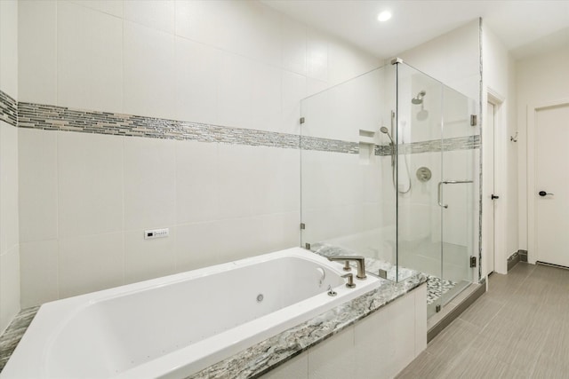 bathroom featuring tile walls and plus walk in shower